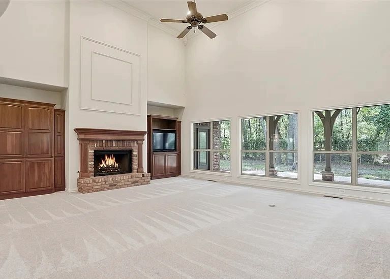 Living room with vaulted ceilings and freshly painted walls around a fireplace